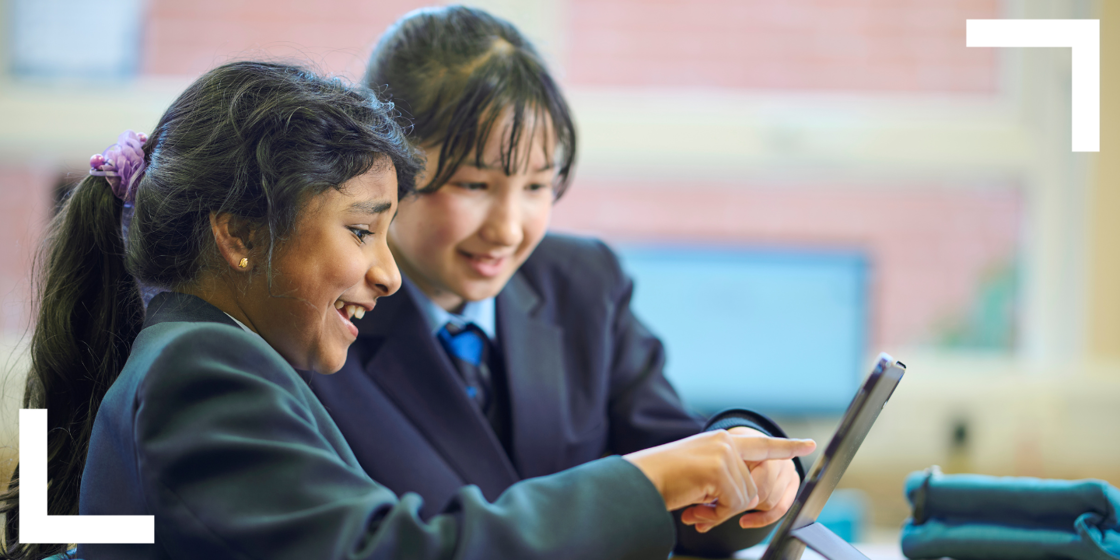 two pupils work together on a tablet