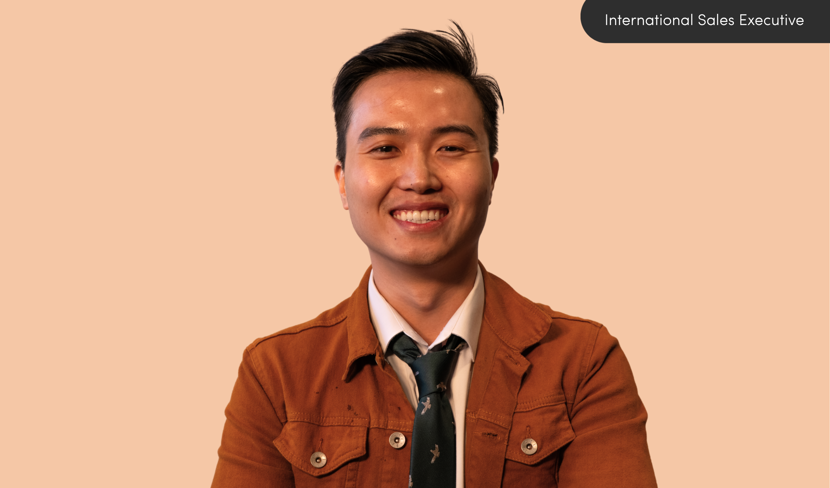 Quyen smiling against orange background