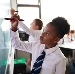 students writing on the whiteboard in class