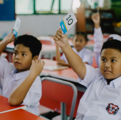 students in class holding up numbers