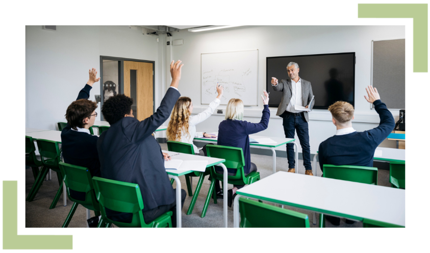 Pupils raising their hands to ask questions in a classroom