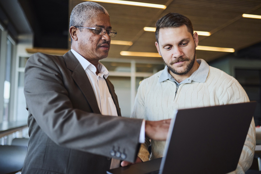 men taking survey on laptop